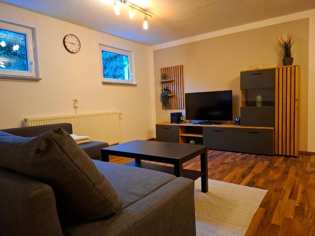 ein Wohnzimmer mit Sofa und Tisch in der Unterkunft Gemütliches Apartment in Giengen an der Brenz