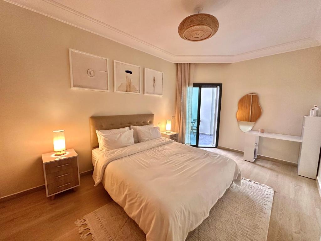 a bedroom with a bed with white sheets and a window at Modern Comfort Studio, la corniche in Mohammedia