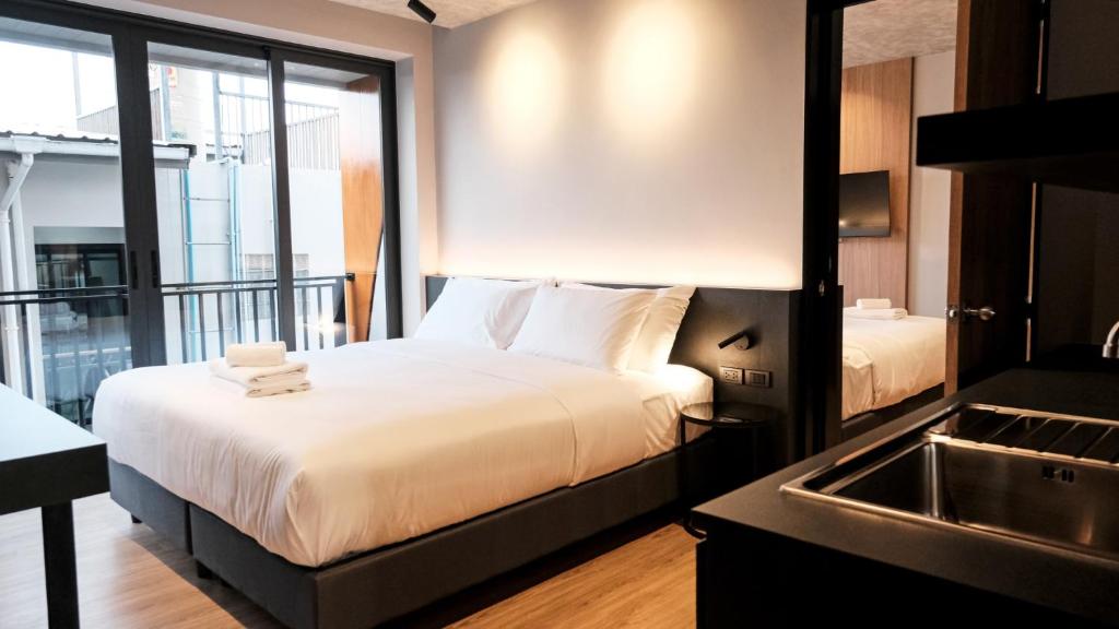 a hotel room with a bed and a sink at Lush inn Phuket in Ban Suan