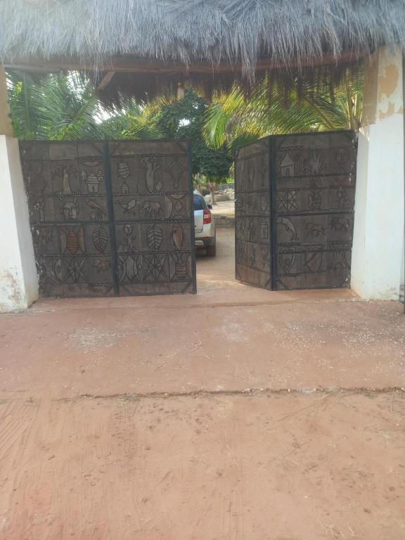 een ingang naar een gebouw met een rieten dak bij Hôtel auberge Sankaranka in Abémé