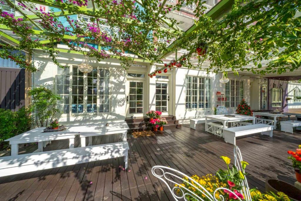 a patio with benches and tables and flowers at GREEN INN in Wujie