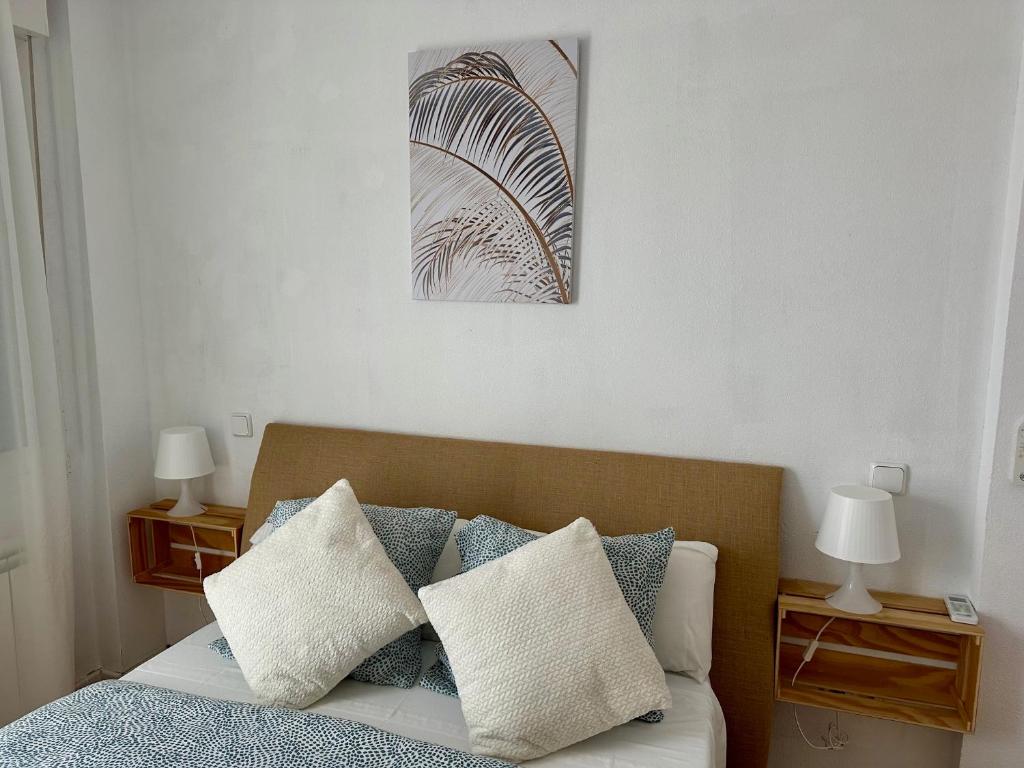 Un dormitorio con una cama con almohadas y dos lámparas. en Los Seis Caños, en Madrigal de la Vera