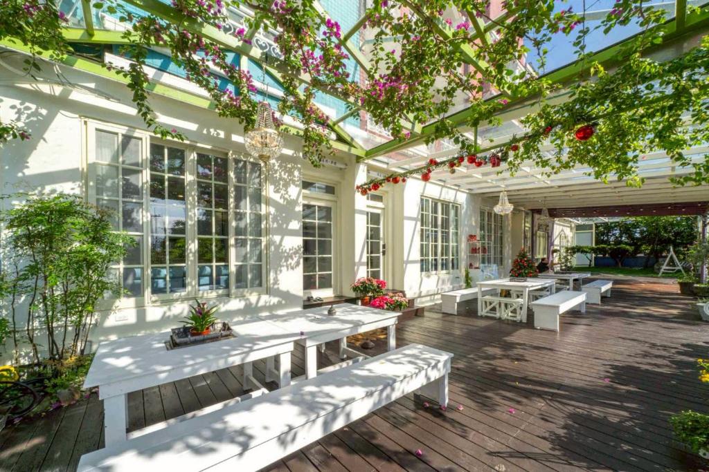 een serre met witte banken en bloeiende planten bij GREEN INN in Wujie