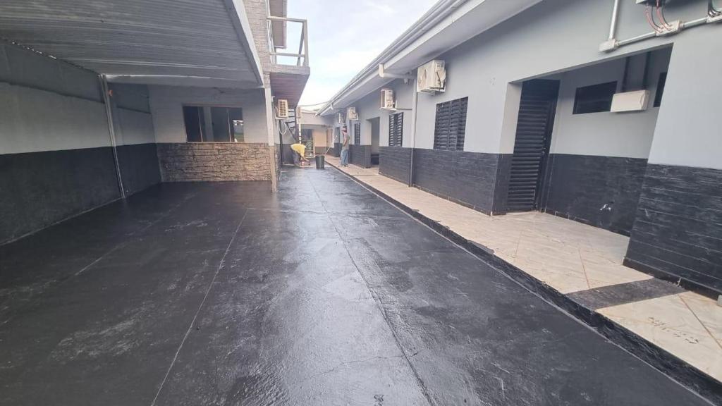 un pasillo vacío de un edificio con una persona a lo lejos en Kitnet, en Ponta Porã