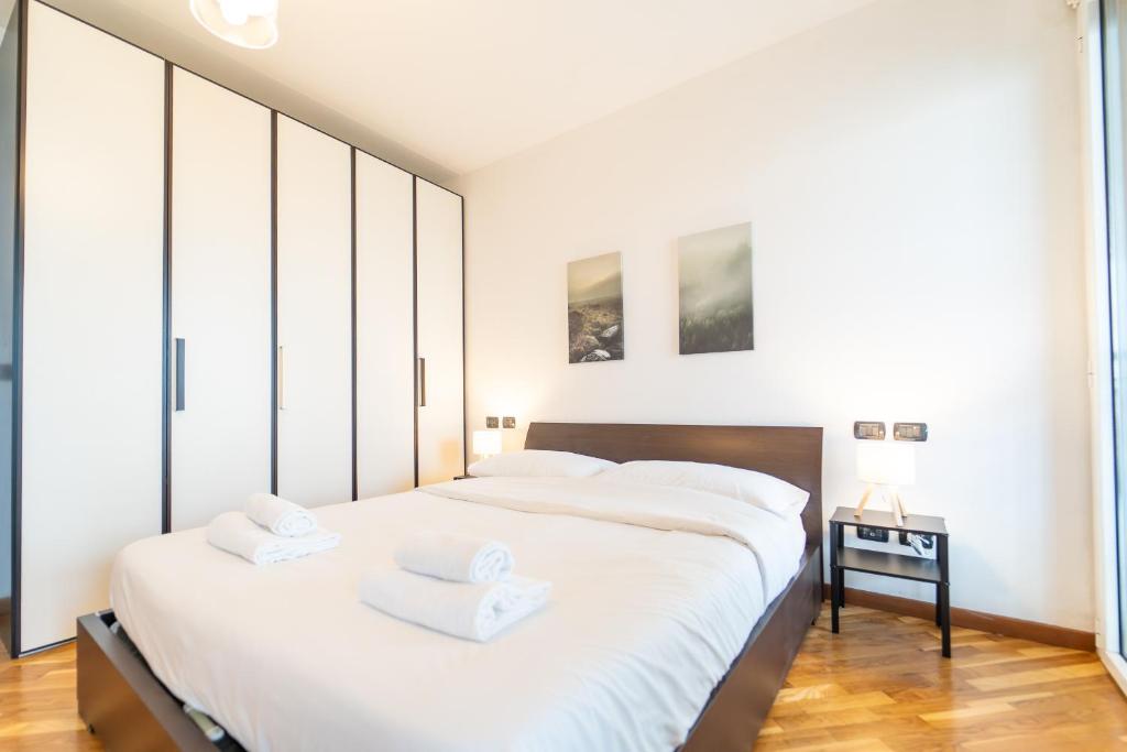 Un dormitorio con dos camas con sábanas blancas. en Moderno appartamento con garage, Wi-Fi, aria condizionata e terrazzo, en Milán