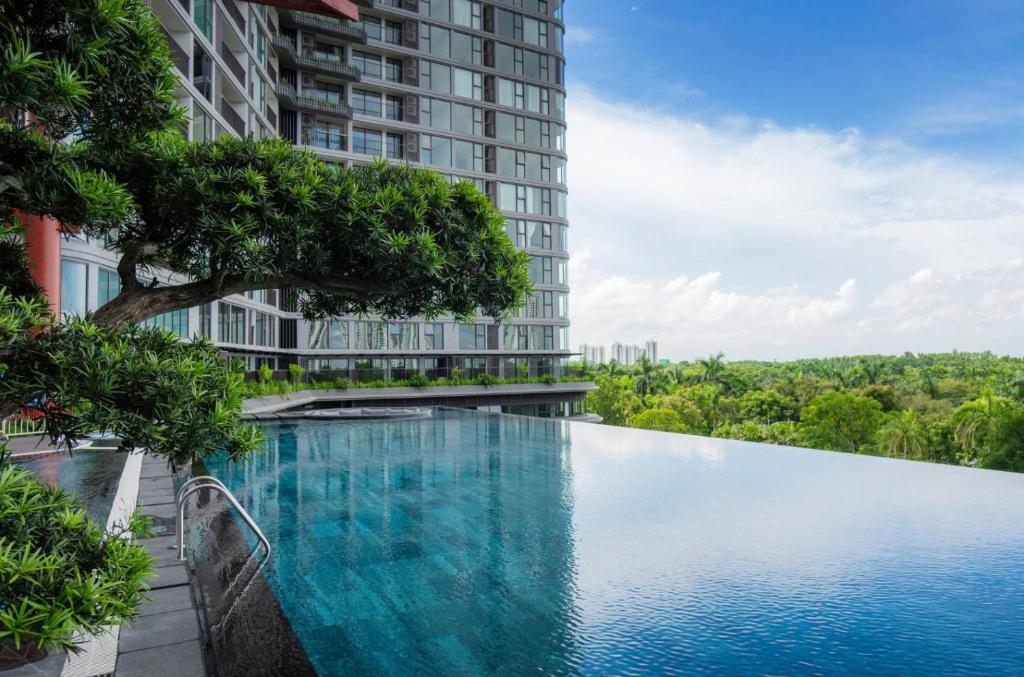 una piscina di fronte a un edificio alto di Sakura Room Ở Space Ecopark a Kim Quan