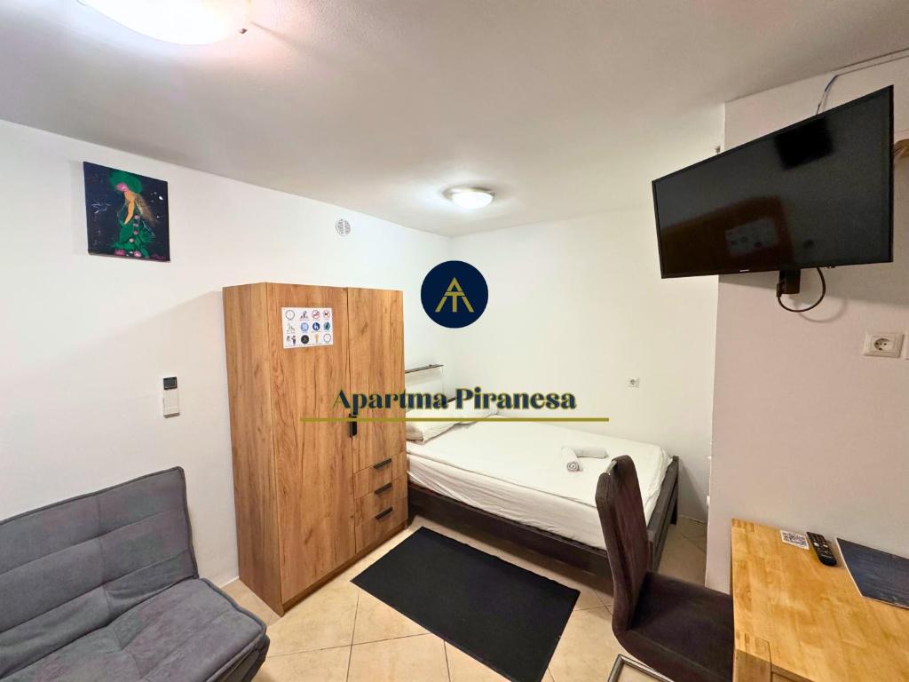 a room with a bed and a couch and a tv at Apartma Piranesa III in Piran