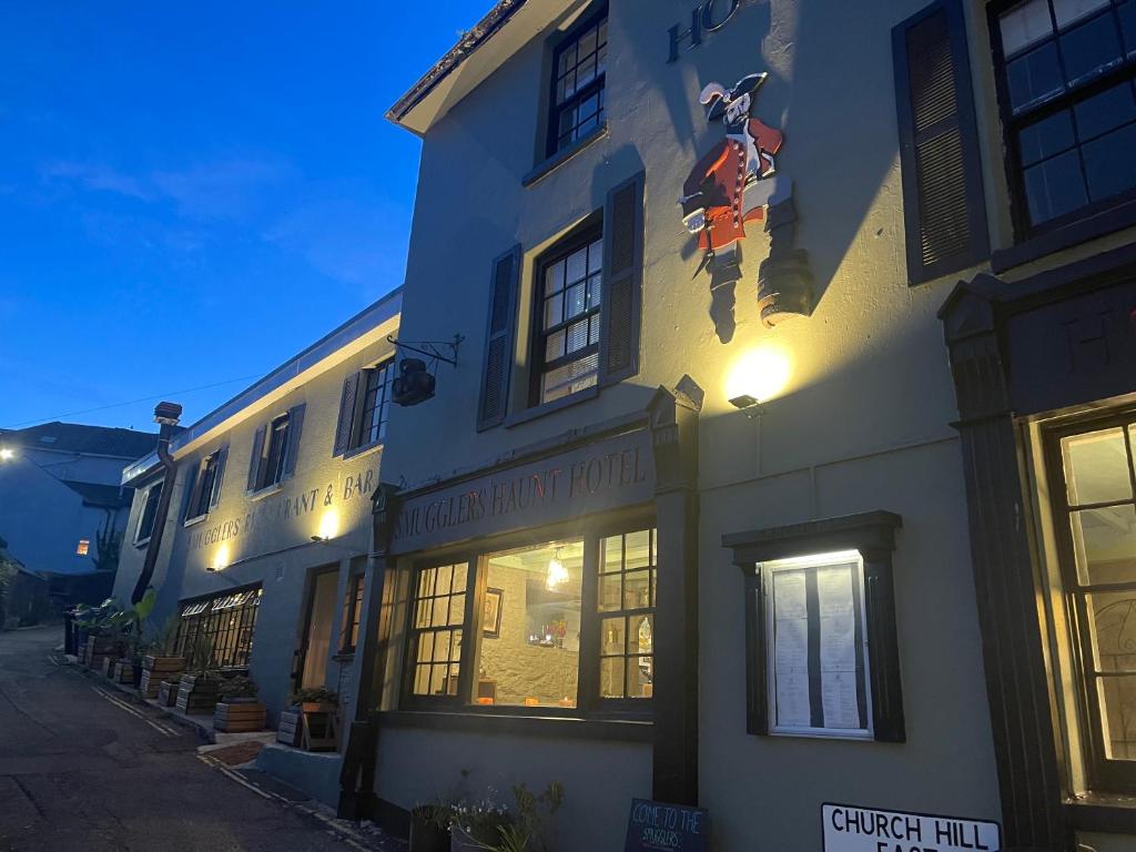 a building with a sign on the side of it at Smugglers Hotel in Brixham