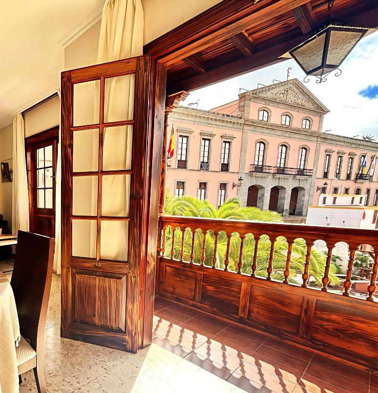 an open door to a balcony with a view of a building at Emblematic Canarian House in La Orotava
