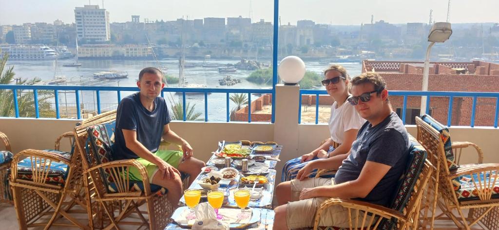 a group of people sitting at a table with food at Masa Nubian House in Aswan