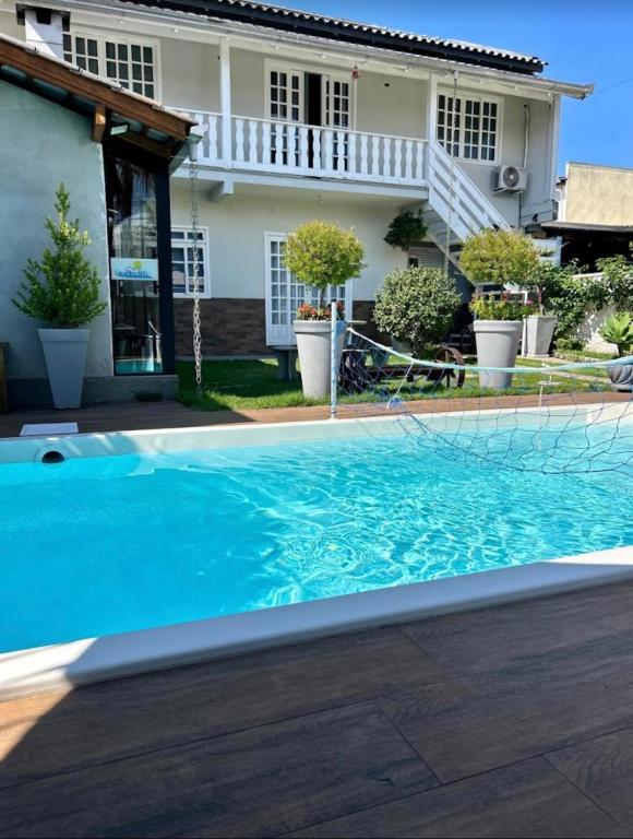 a swimming pool in front of a house at Casa com piscina Aquecida Balneário Camboriú CasaAlbertiBc in Balneário Camboriú