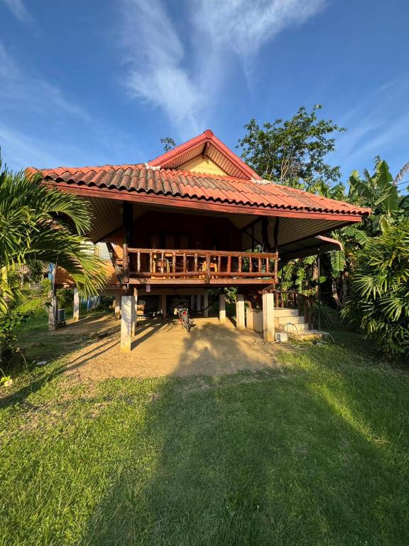 a large house with a roof with a porch at Family house in Ban Laem Sai