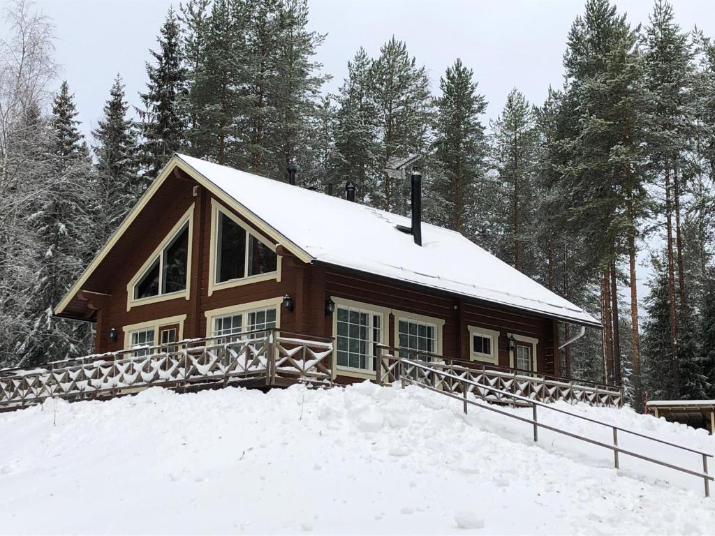 a house covered in snow in the woods at Jämsän Lomamökit in Jämsä