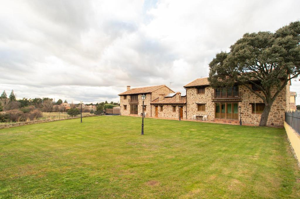 a large yard in front of a stone house at Complejo Rural La Venta Vieja by CABANA Rentals in Ortigosa del Monte