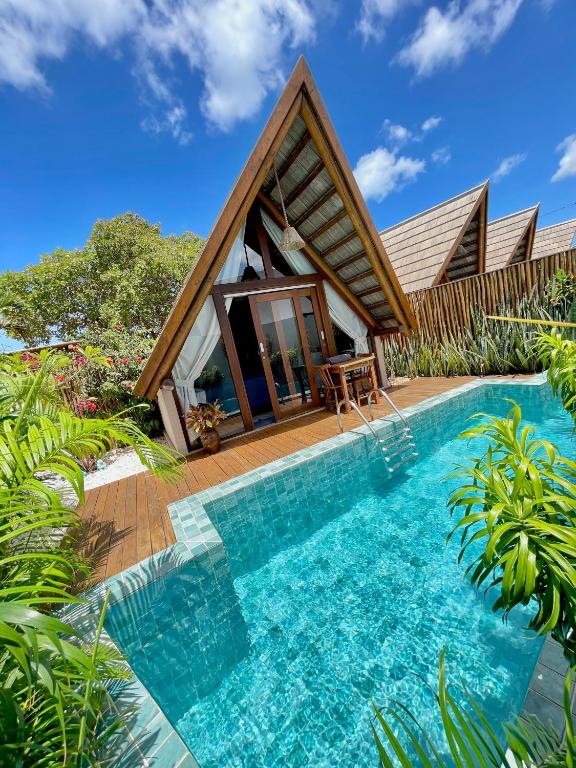 a villa with a pool and a house at Pousada Villa di Luna in São Miguel do Gostoso