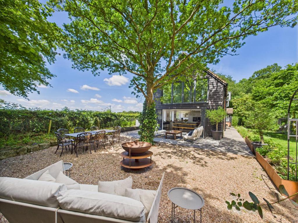 Luxurious 4 Bed Property: Chiltern Hills - Pass the Keys في Ibstone: بيت فيه شجره وسط ساحه