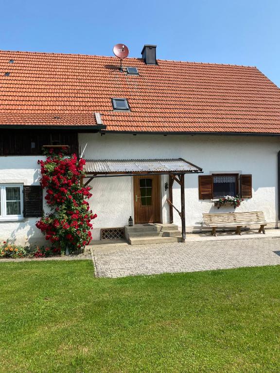a white house with a bench and a red roof at Ferienhaus Haas in Laufen