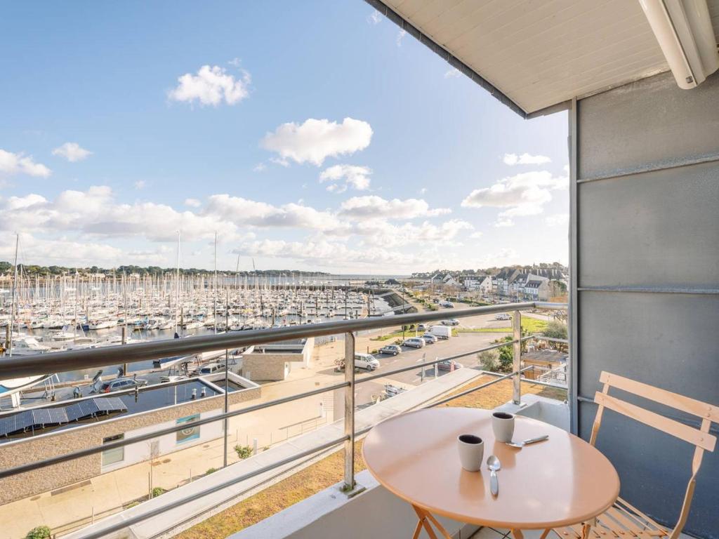 a balcony with a table and a view of a harbor at Charmant T2 avec vue port, idéal pour 4 pers. à La Trinité-sur-Mer - FR-1-477-78 in La Trinité-sur-Mer