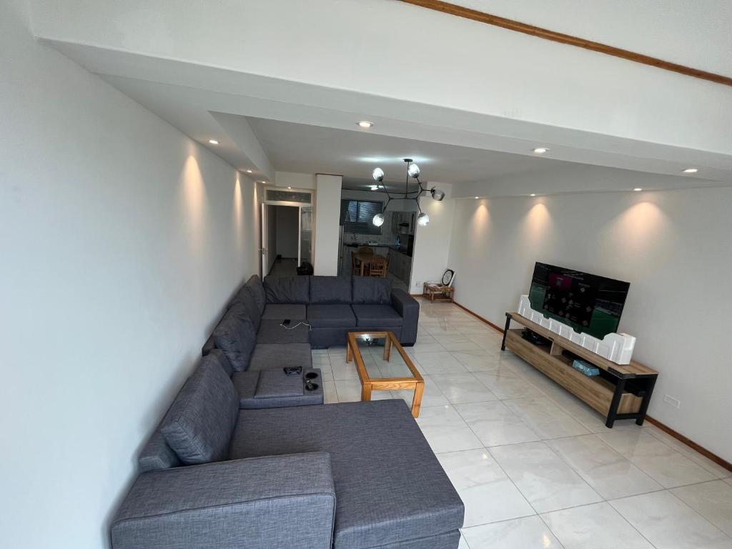 a living room with a couch and a tv at By the Sea in Swakopmund