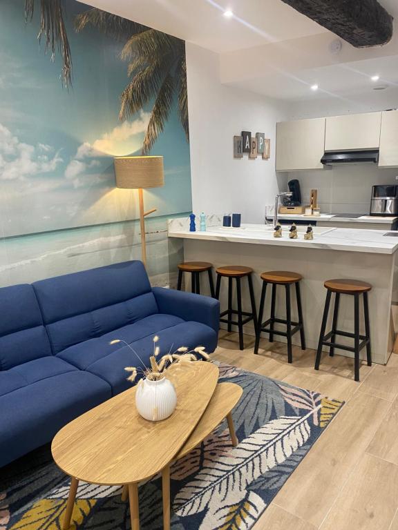 a living room with a blue couch and a table at L'horizon De Coursan in Coursan