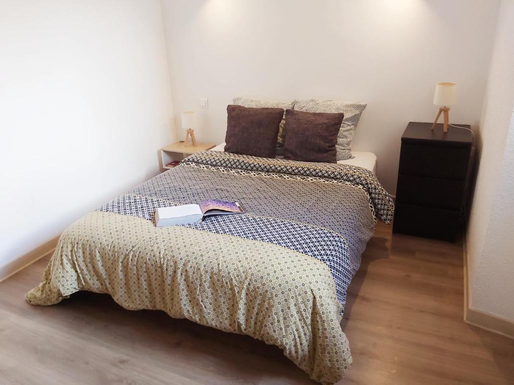 Foix centre - T2 vue sur le Château في فوا: غرفة نوم بها سرير مع كتاب عليها