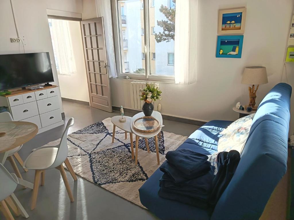 a living room with a blue couch and a table at T2 a St Nazaire, 500 mètres de la plage in Saint-Nazaire