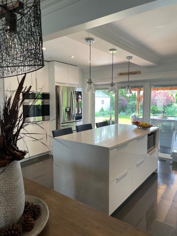 a kitchen with white cabinets and a large island at Modern Retreat with Hot tub by YYZ, 20min to CN Tower in Toronto