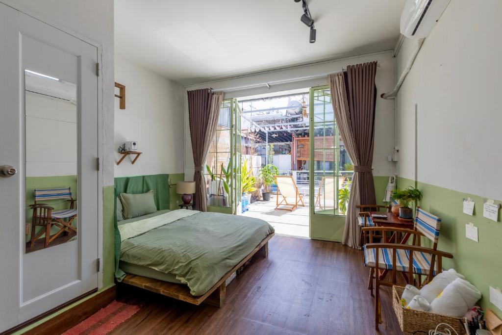 ホーチミン・シティにあるKibou Homestayのベッドとガラスの引き戸のある寝室
