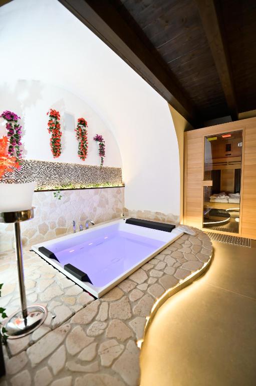 a bath tub in a room with a stone wall at Eterea Wellness Suites in Montescaglioso
