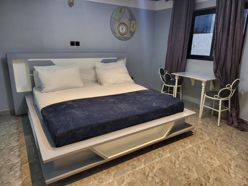 a bedroom with a large bed and a table at Ndouha House in Bafoussam