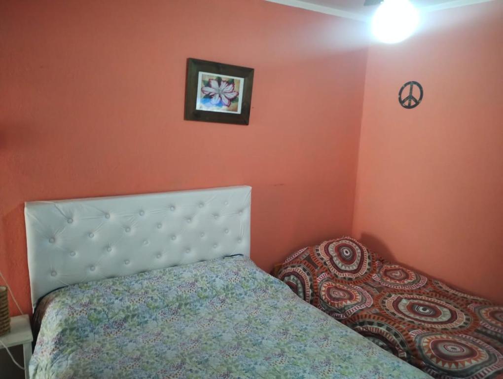 a bedroom with a bed and a picture on the wall at Depto San Clemente 3 in San Clemente del Tuyú