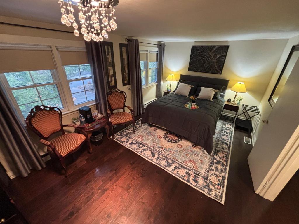 Vintage Pines Guest House في نياغرا اون ذا ليك: غرفة نوم بسرير وكرسيين وثريا