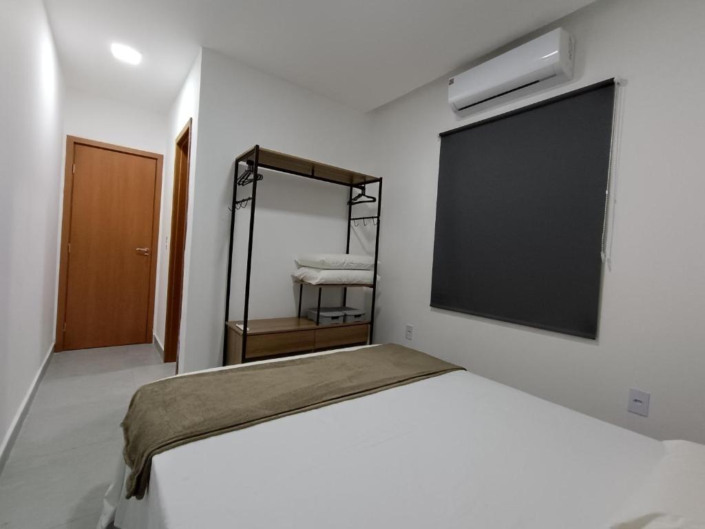 コンデにあるCasa de Praia com Piscina Coqueirinho João Pessoaの壁に大きなスクリーンが付いたベッドのある寝室