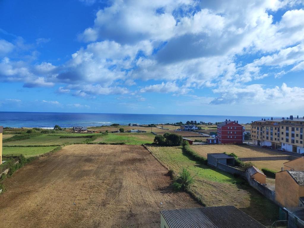 an empty field with the ocean in the background at Amanecer en Playa de LLás in Foz