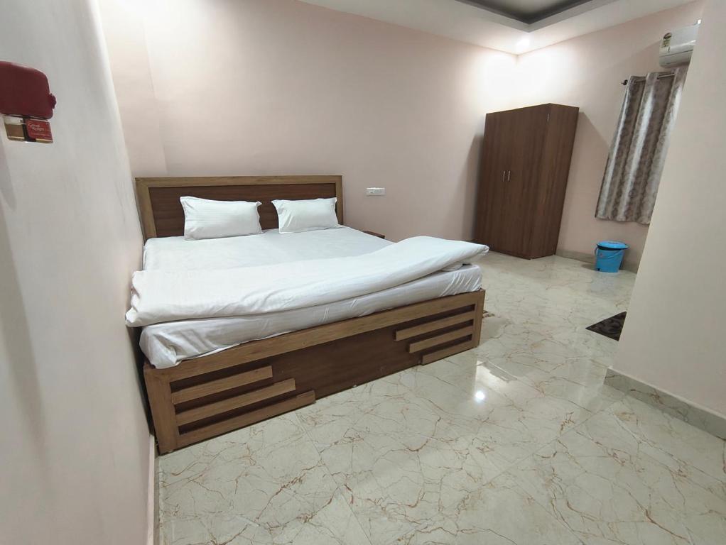 ein Schlafzimmer mit einem großen Bett mit weißer Bettwäsche in der Unterkunft Hotel Ardent in Ranchi