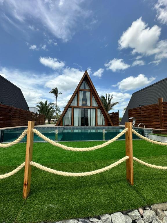 una casa con una recinzione di corda di fronte a una casa di LIMMAT Chalés a Hora