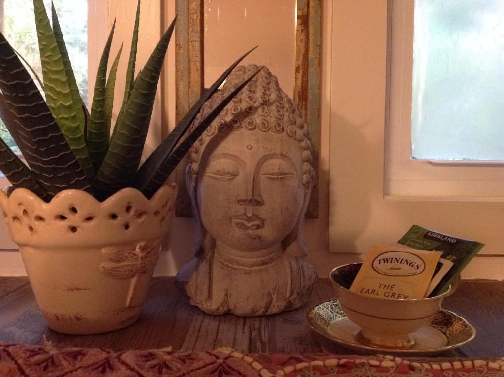 a table with a statue of a head next to a plant at Magnolia Petal in Ganges