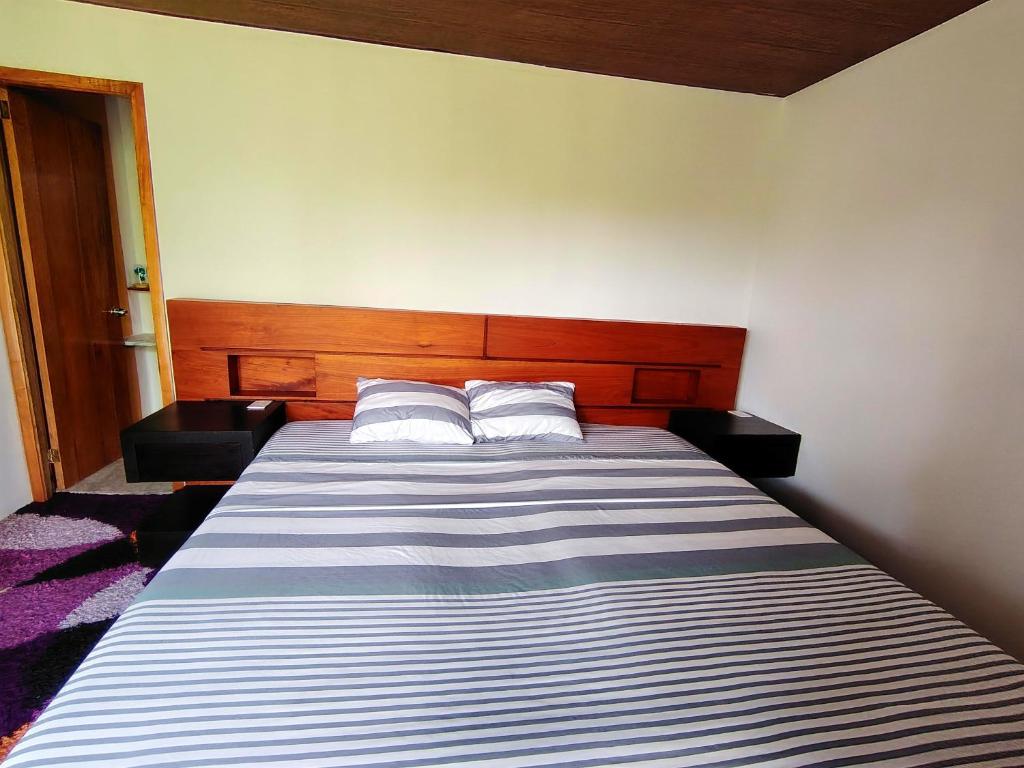 Homestay Natural Paradise habitación 3 في سان كريستوبال: غرفة نوم بها سرير كبير مع وسادتين