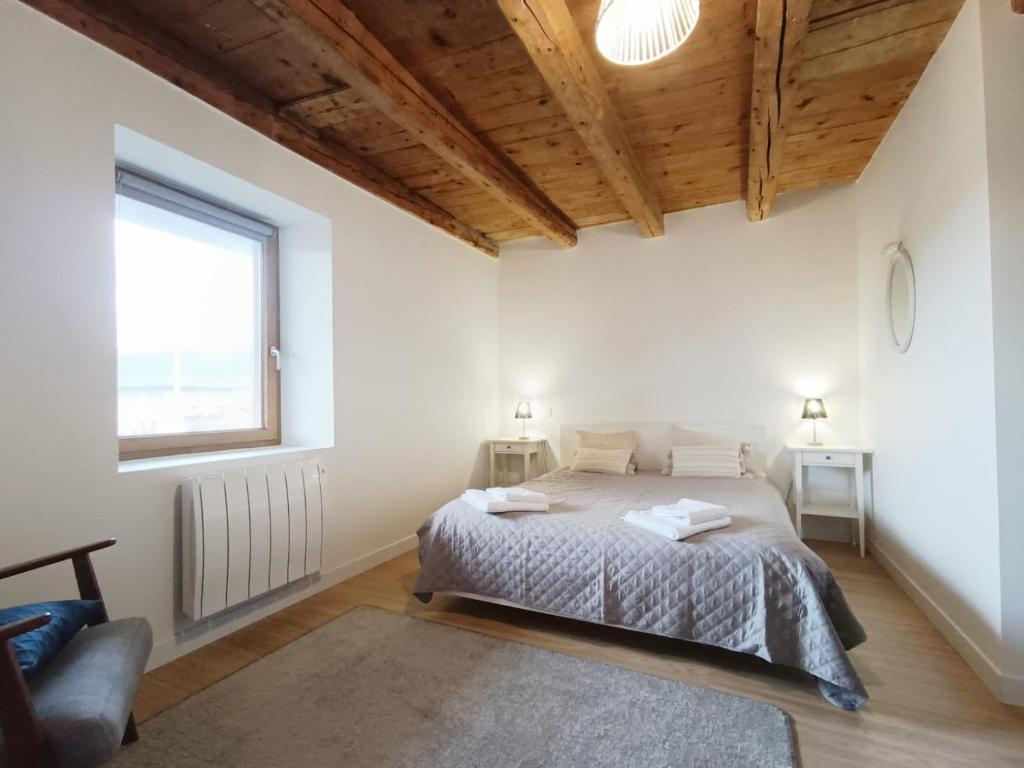 Una habitación blanca con una cama y una ventana en Le Parmelan - Sur la route d'Annecy, en Alby