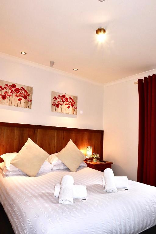 a bedroom with a large white bed with white pillows at Riverside Hotel in Norwich