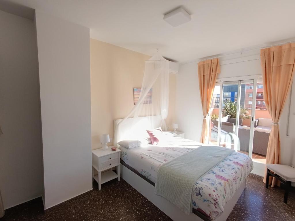 a white bedroom with a bed and a window at Cozy and sunny penthouse Fira BCN in Hospitalet de Llobregat