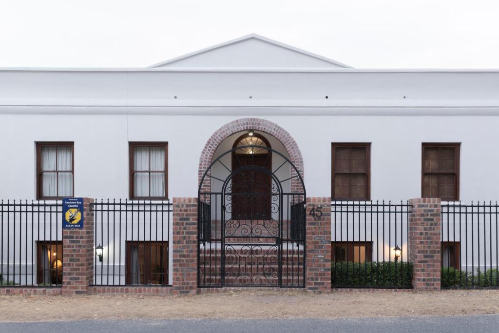 a white building with a gate in front of it at Mountain and Tides in Kleinmond