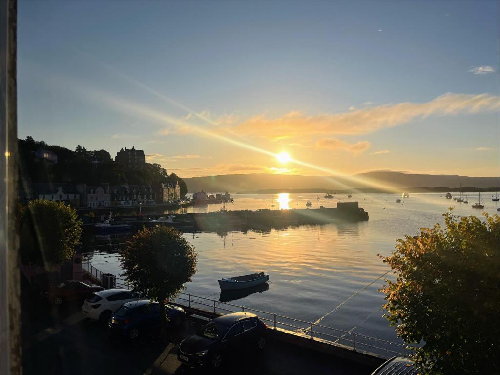 a sunset over a river with boats in the water at Harbourside in Tobermory