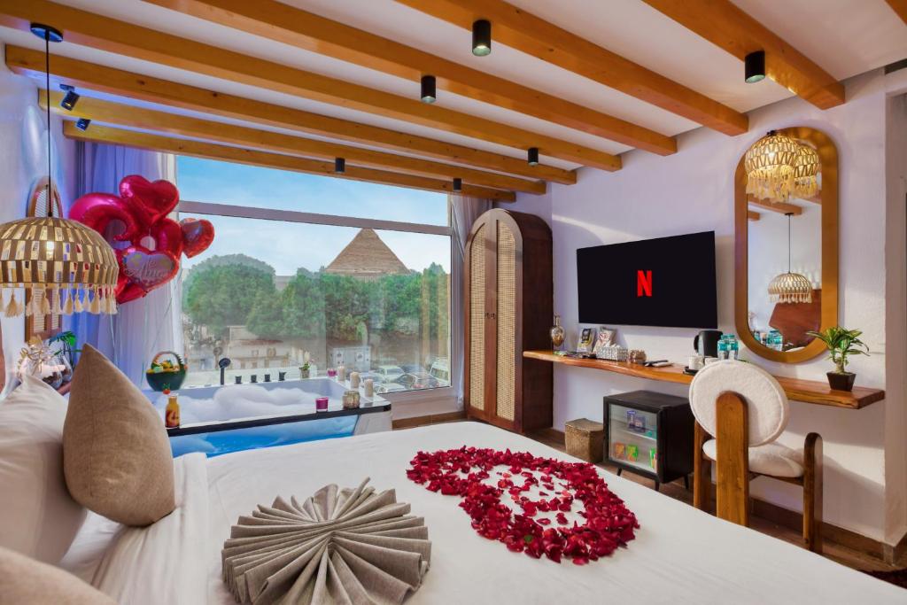 een slaapkamer met een bed met een groot raam bij Pyramids Vision Hotel in Caïro