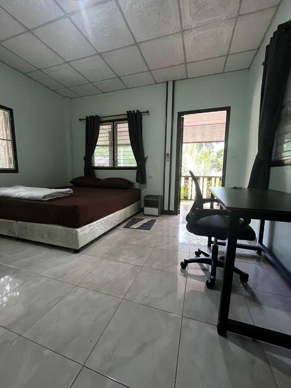 Un dormitorio con una cama, un escritorio y una mesa. en Lotus Garden House, en Ko Pha Ngan