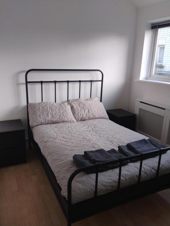 a bed in a bedroom with a black metal bed frame at Caminetto in Croydon