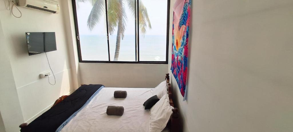 a bedroom with a bed with a view of the ocean at SALT beach resort classic in Kālapettai