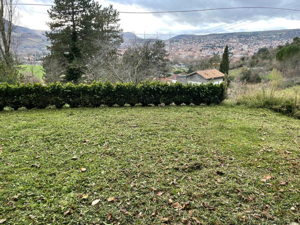 a field of grass with a hedge in the background at Vue SUR VIADUC DE MILLAU in Millau
