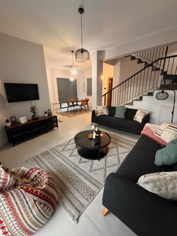 a living room with two couches and a table at Maroulla's Modern & Spacious Family Home near the Beach in Limassol