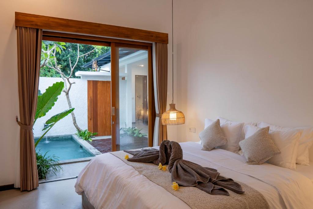 a bedroom with a bed with a robe on it at 2BR Private Pool Beach Villa Near Sanur & Ubud in Ketewel